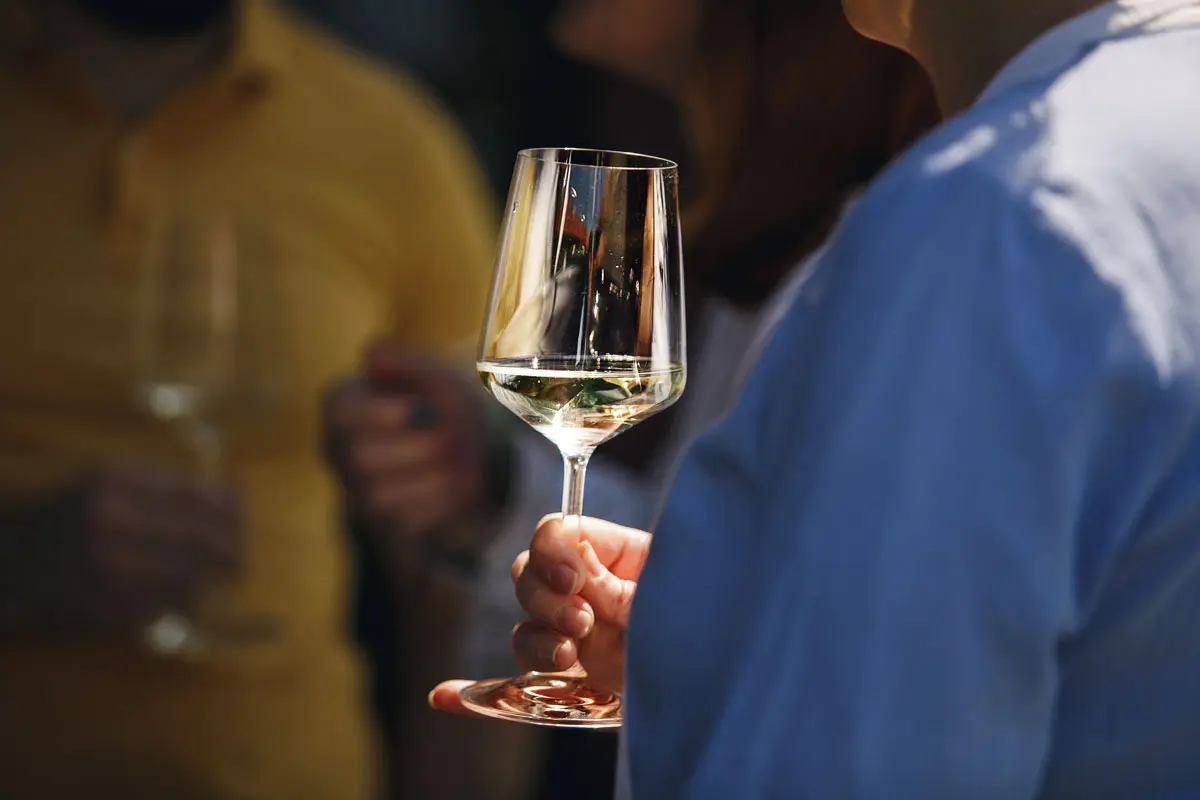 Un homme tient un verre de vin blanc