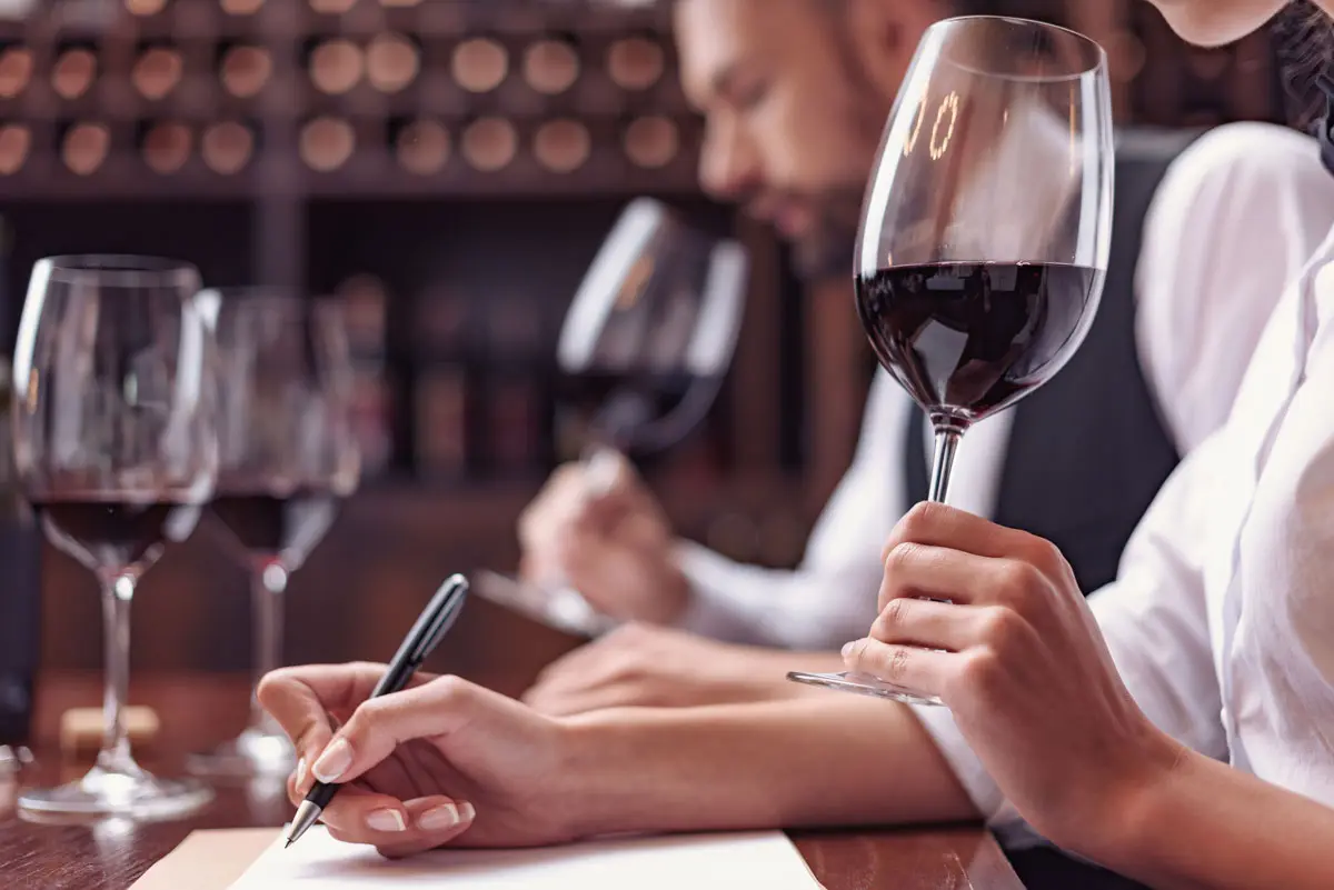 Ue personne sent un verre de vin lors d'une dégustation